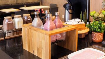 A buffet setup with various food items and condiments.