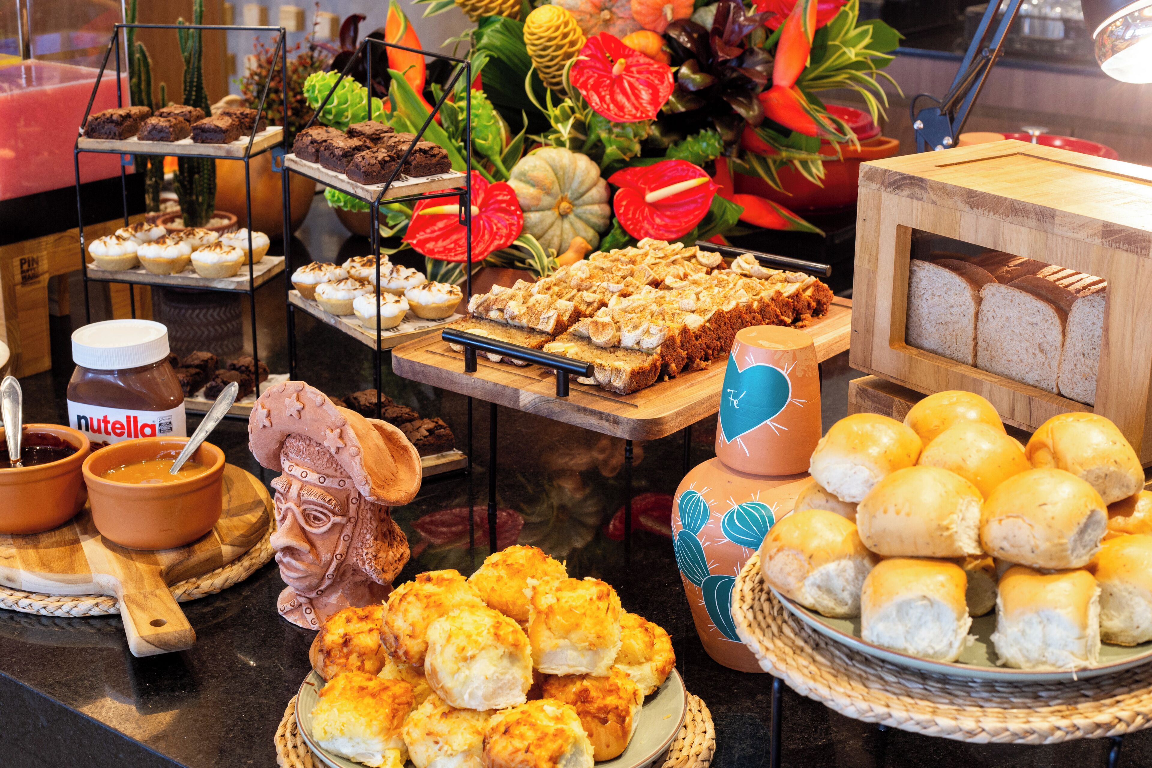 A buffet with various food items including bread, pastries, and desserts.