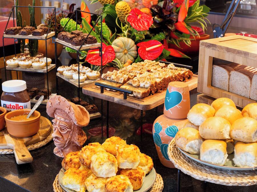 A buffet with various food items including bread, pastries, and desserts.