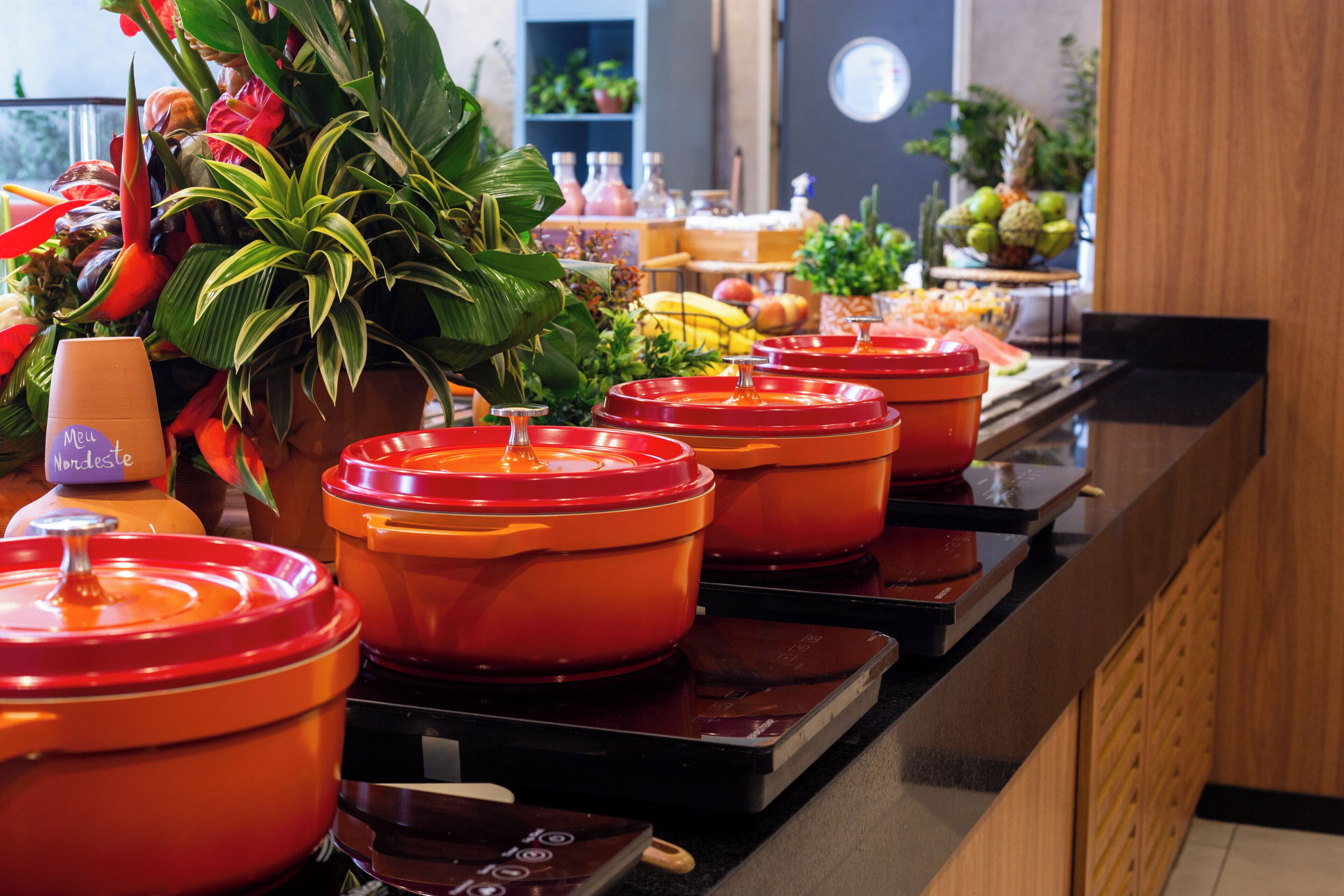 A buffet with various food items and a potted plant.
