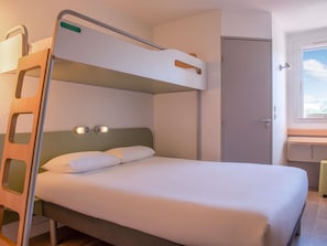 Una cama litera con escalera, una mesita de noche, una lámpara de pared y una puerta.