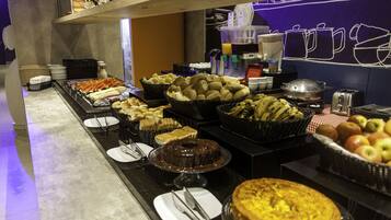 A buffet with various food items and a coffee station.