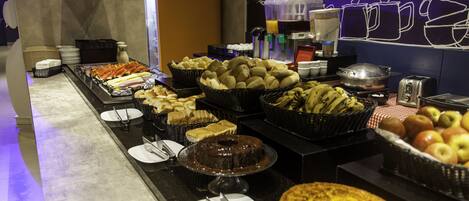 Un buffet con diversi cibi e un angolo caffè.