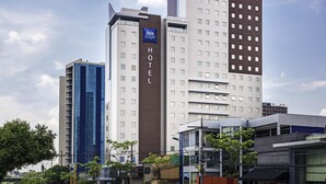 A modern hotel building with a prominent 'ibis budget' sign, multiple floors, and a mix of glass and concrete facades. - ibis budget Manaus (Manaus)