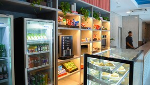 A hotel lobby with a self-service beverage station, snack shelves, and a pastry display. - ibis budget Rio de Janeiro Centro (Rio de Janeiro)