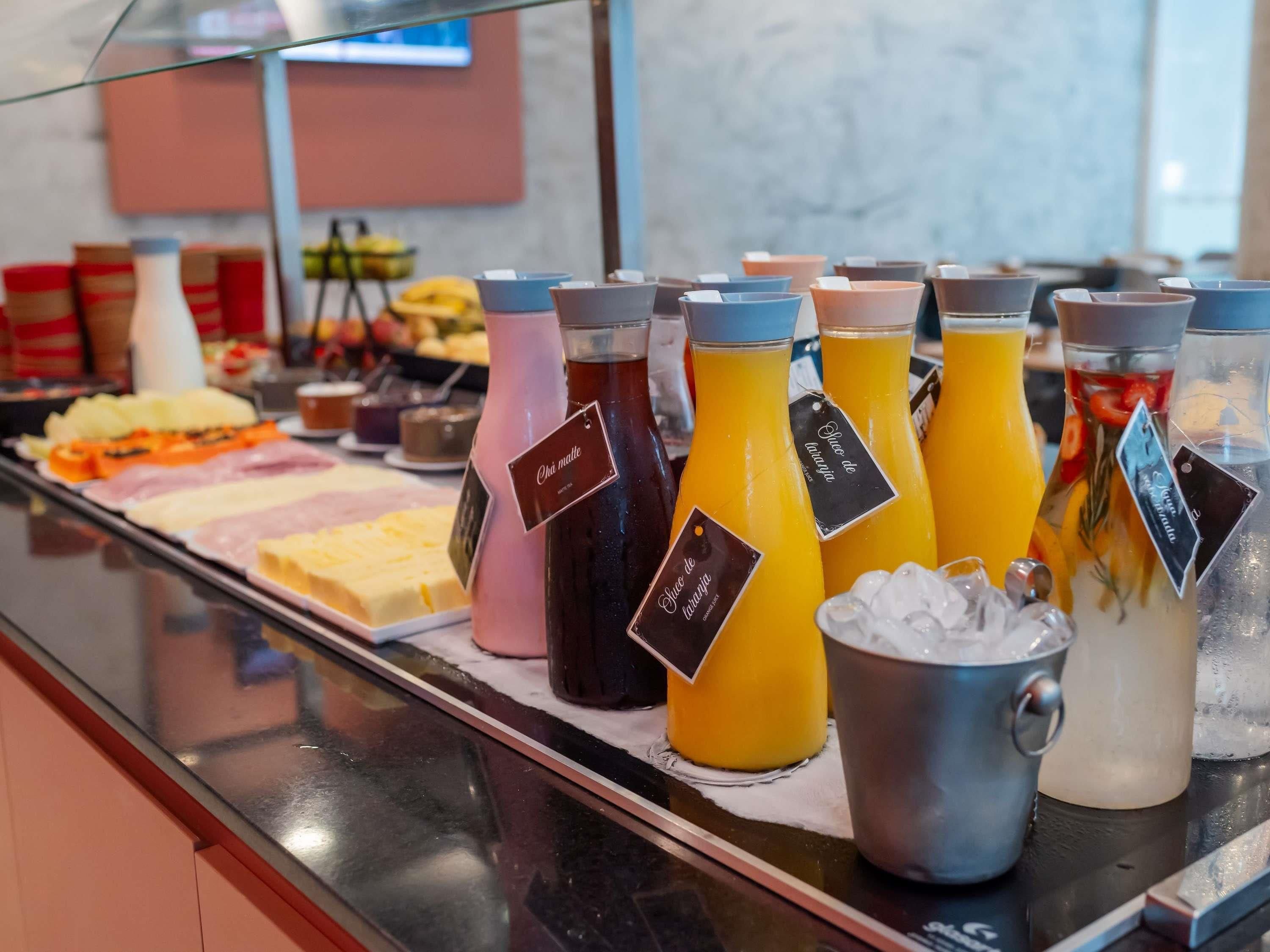 A buffet with various food items and beverages, including a selection of juices and a pitcher of water.