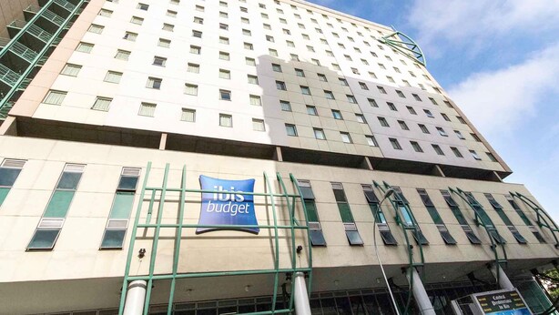 A multi-story hotel with a prominent 'ibis budget' sign, featuring a modern architectural design with a grid of windows and a flat roof. - ibis budget Rio de Janeiro Centro (Rio de Janeiro)