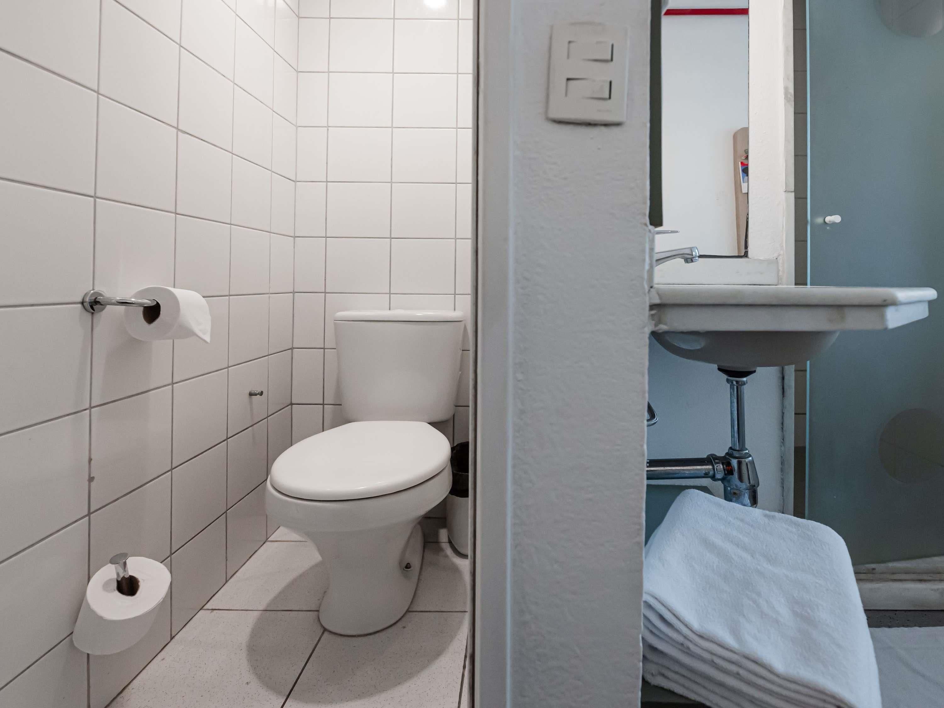 Une salle de bain avec des toilettes, un lavabo et un porte-serviettes.