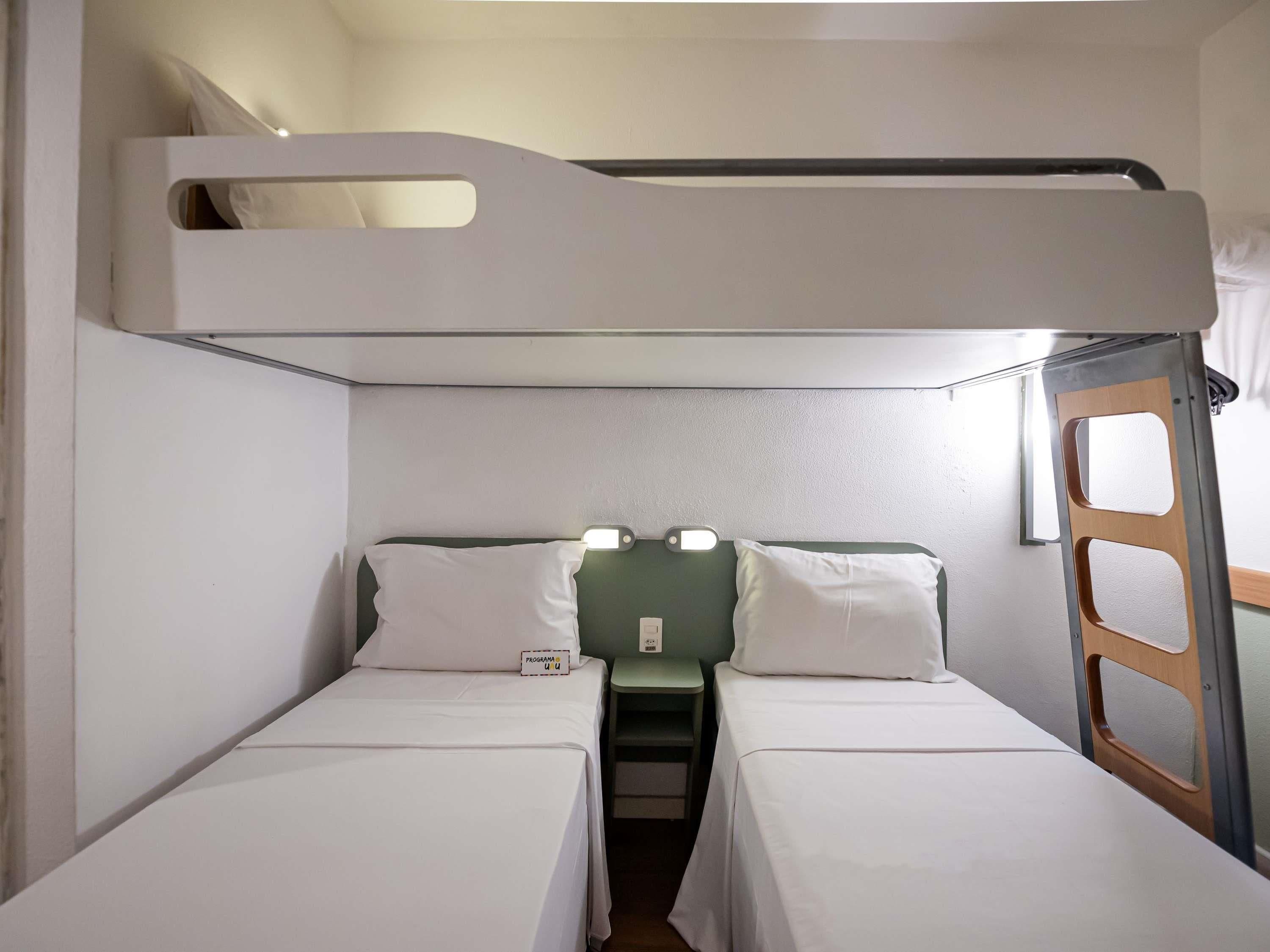 A bunk bed room with two beds and a small table.