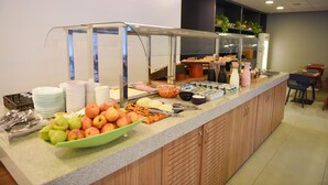 A buffet setup with various food items and utensils. - ibis budget Rio de Janeiro Centro (Rio de Janeiro)