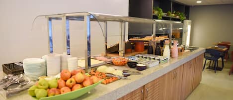 A buffet setup with various food items and utensils.