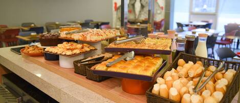 A buffet with various baked goods and pastries.
