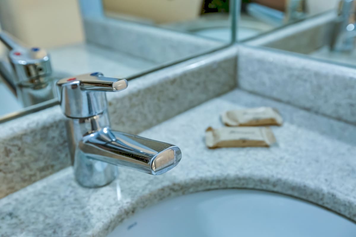 A bathroom sink with a chrome faucet and a mirror above it.