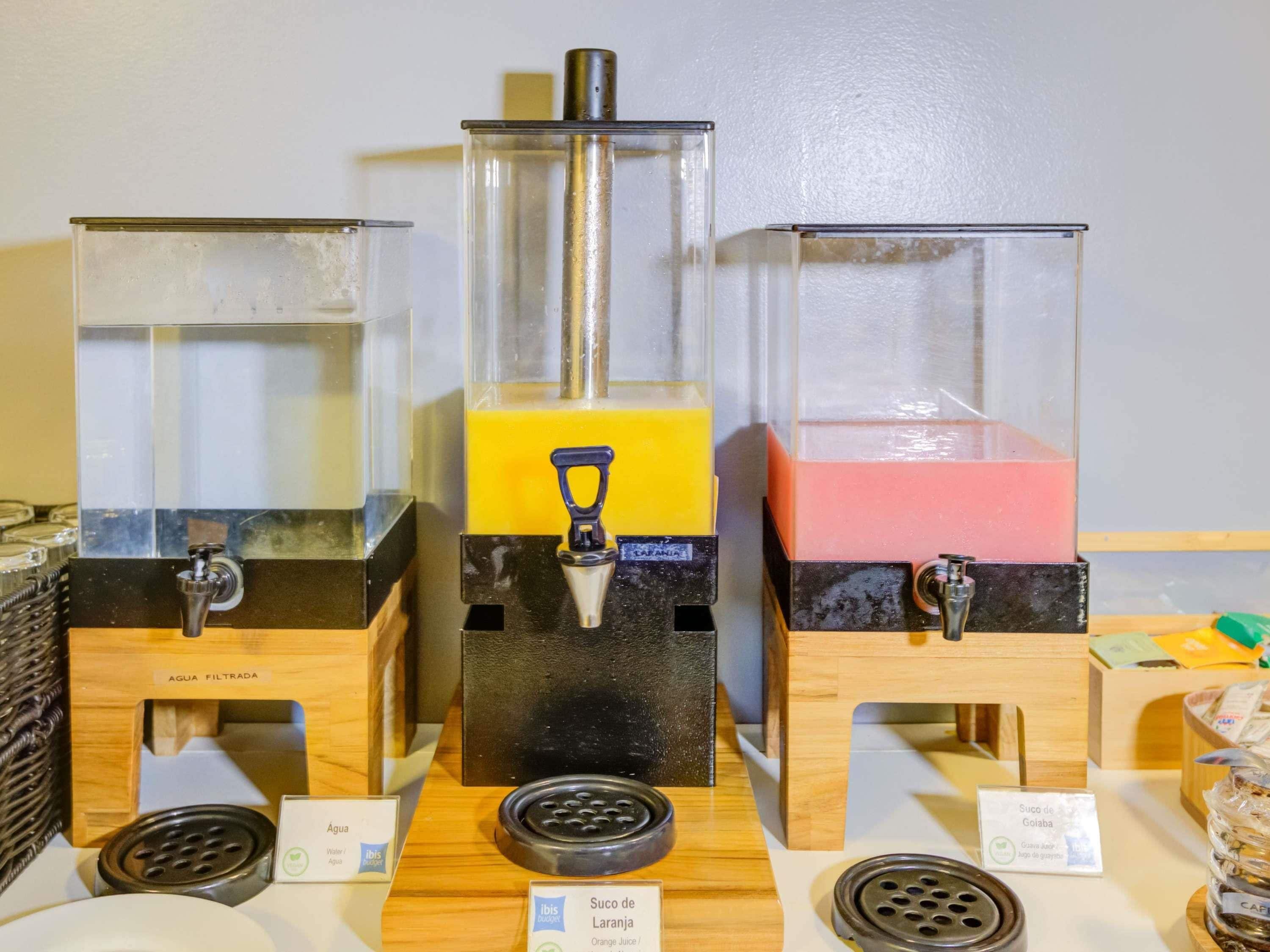 Trois distributeurs de boissons contenant des liquides de couleurs différentes, un distributeur avec filtre à eau et un moulin à café.