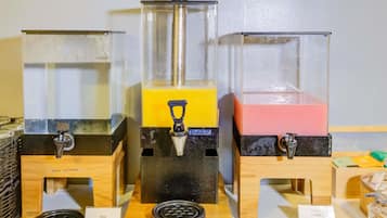 Trois distributeurs de boissons contenant des liquides de couleurs différentes, un distributeur avec filtre à eau et un moulin à café.