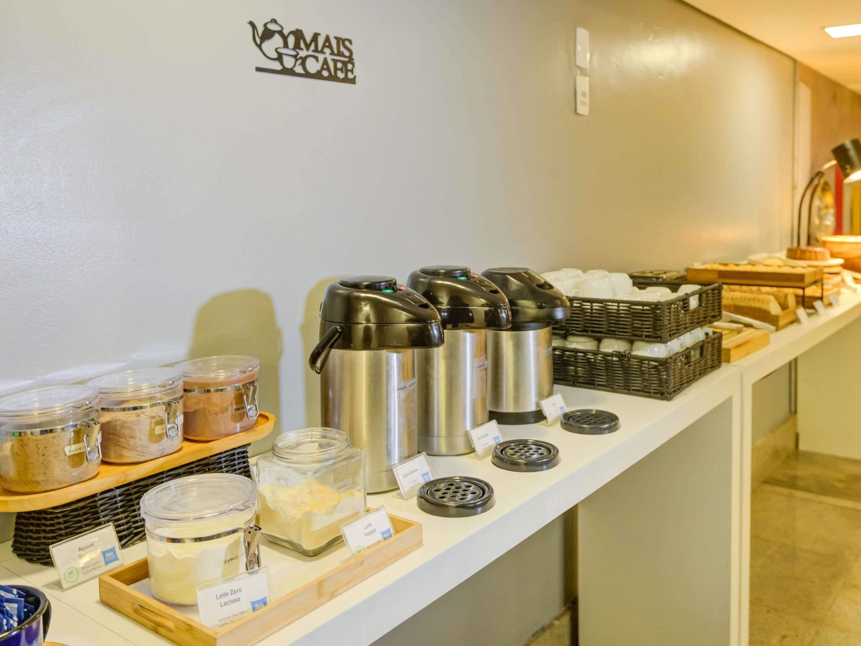 Un buffet allestito con diversi contenitori per alimenti e macchine da caffè.