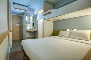 A hotel room with bunk beds, a bedside table, a mirror, and an air conditioning unit. - ibis budget Rj Copacabana (Rio de Janeiro)