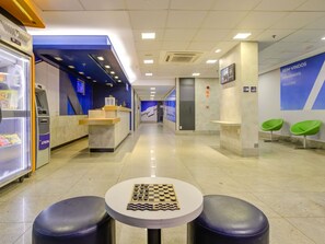 A modern lobby with a reception desk, ATM, vending machine, and a chess table. - ibis budget Rj Copacabana (Rio de Janeiro)