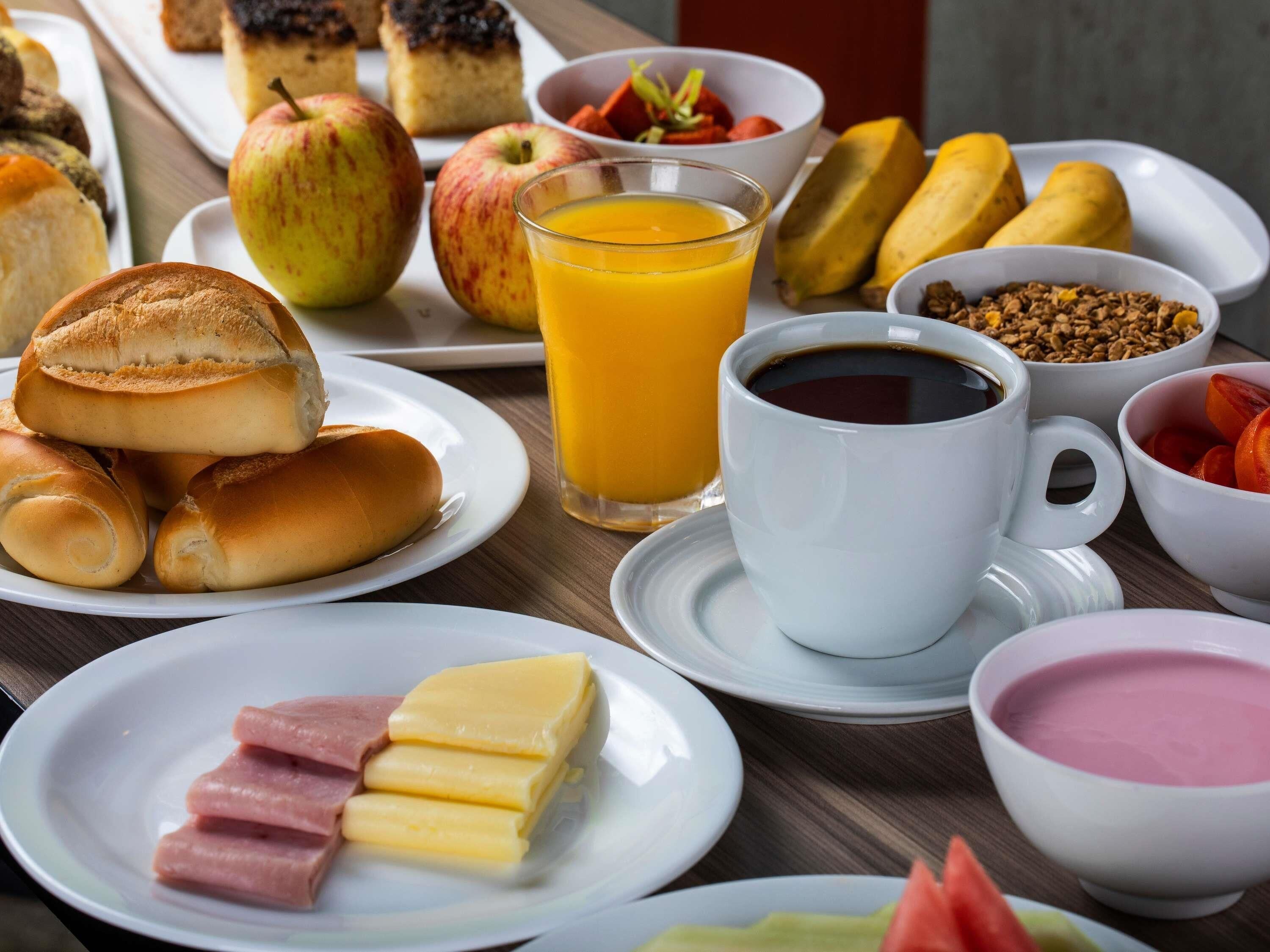 A breakfast setting with various food items and a cup of coffee.