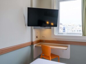A room with a television mounted above a desk, a window, and a chair. - ibis budget RJ Praia de Botafogo (Rio de Janeiro)