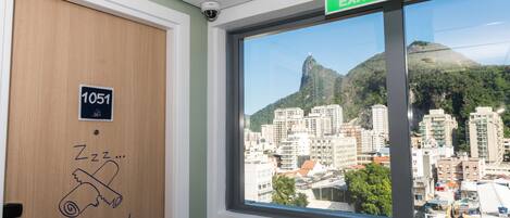 Habitación de hotel con vista a un paisaje urbano y una montaña.