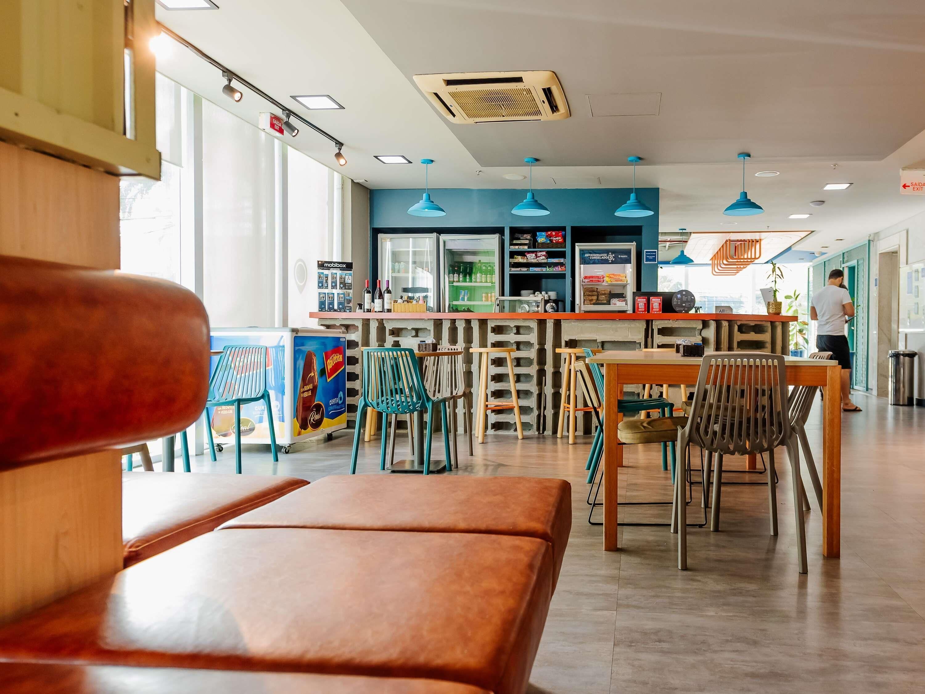 Interior moderno de café com assentos, balcão e vista para a rua.