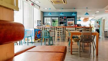Interior moderno de café com assentos, balcão e vista para a rua.
