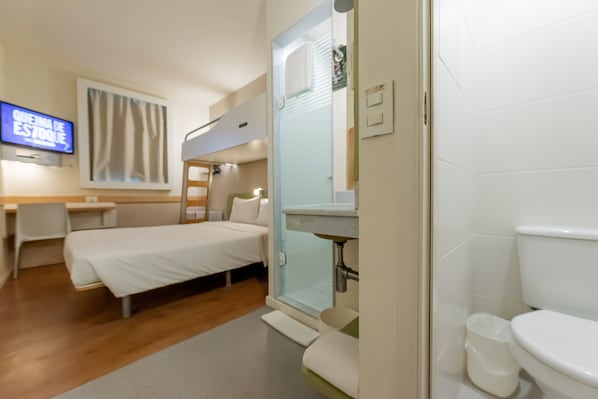 A hotel room with a bed, a desk, a television, and a bathroom. - ibis budget Vitoria (Vitoria)