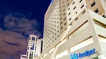 A hotel with a modern facade, multiple floors, and a prominent signage for 'ibis budget hotels'.