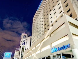 A hotel with a modern facade, multiple floors, and a prominent signage for 'ibis budget hotels'.