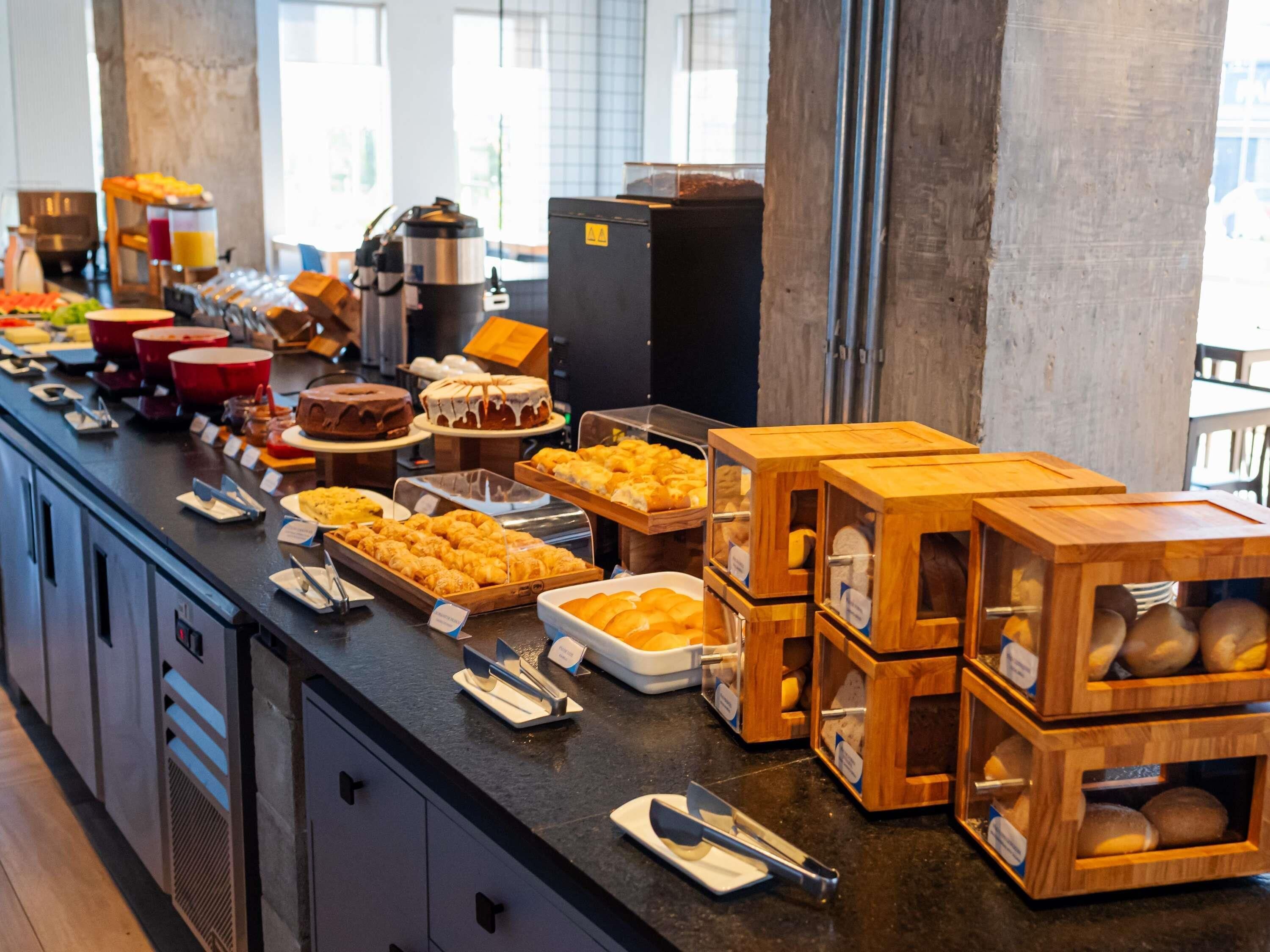 Buffet com diversos alimentos e uma máquina de café.