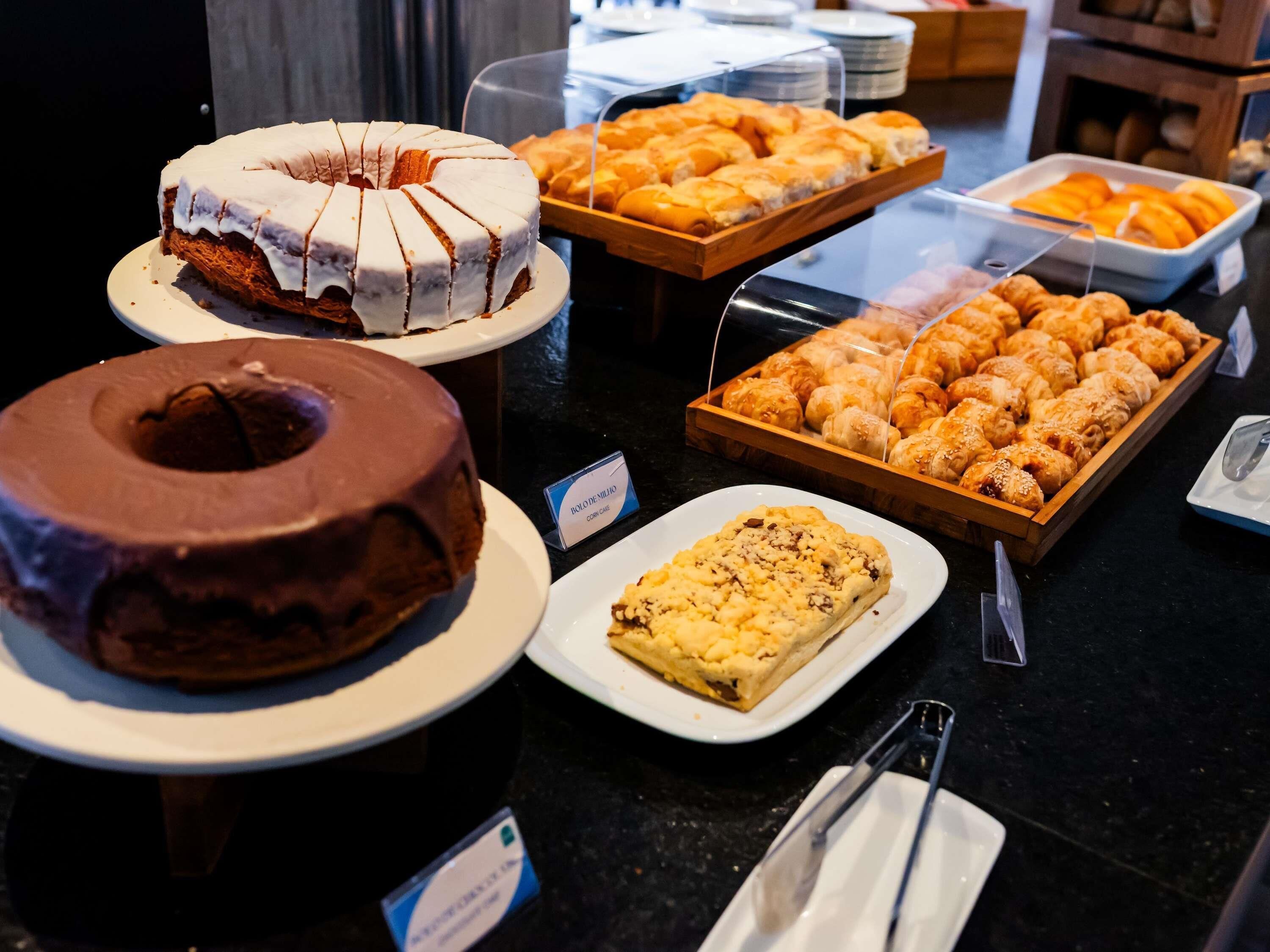 A variety of baked goods on display, including a chocolate cake and pastries.