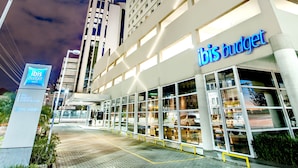 A modern hotel with a prominent 'ibis budget' sign, a glass facade, and a paved entrance area. - ibis budget Porto Alegre - Supereconômico (Porto Alegre)