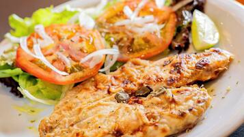 Un plato de pollo a la parrilla con una ensalada.