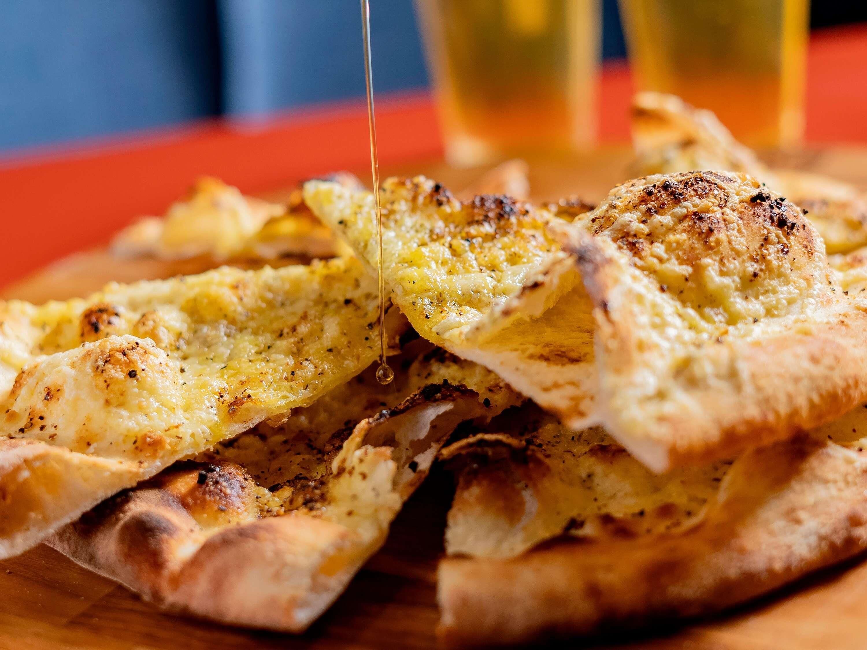 A close-up of a pizza with melted cheese and a drizzle of sauce.
