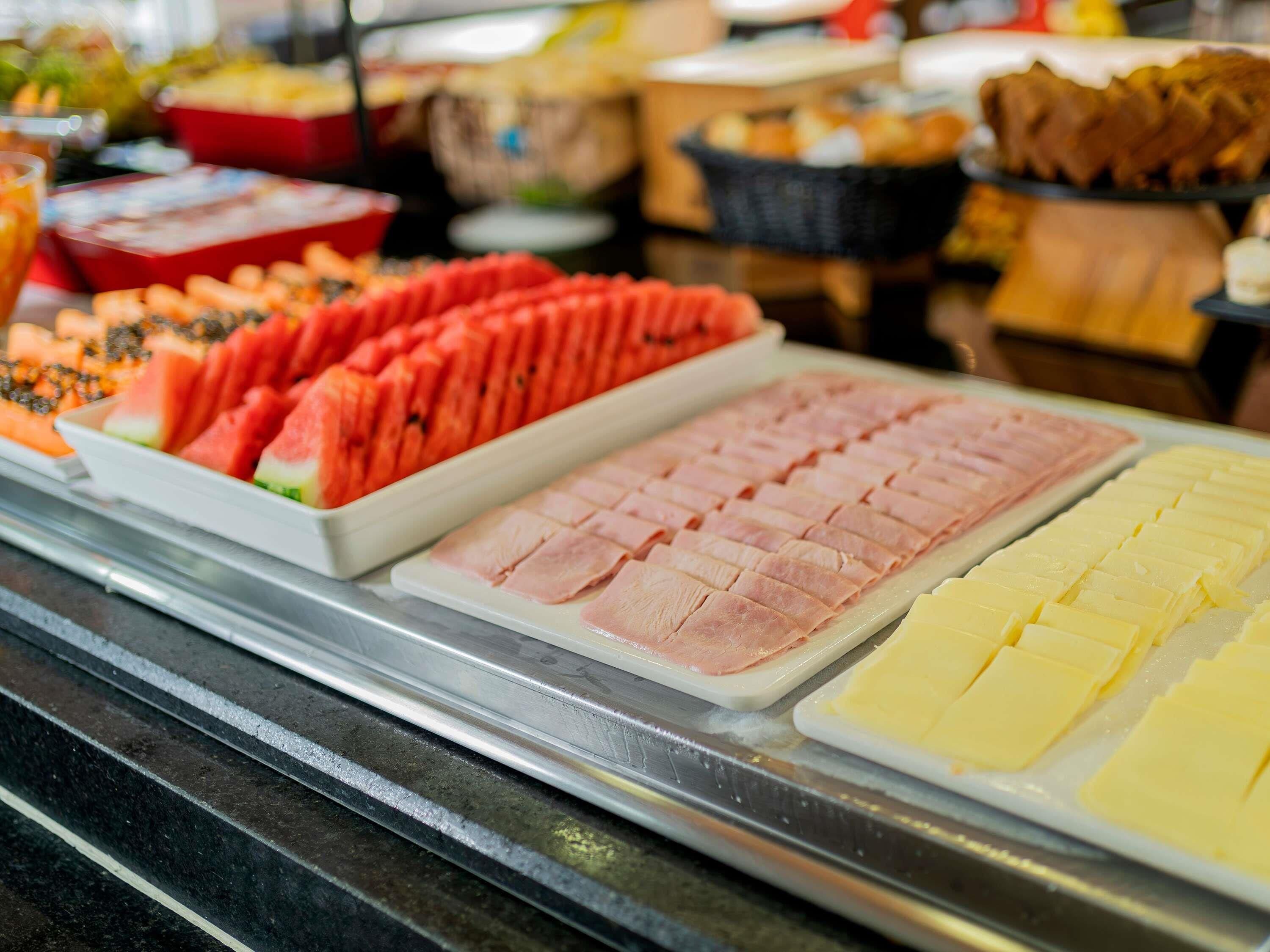 Buffet amb diferents aliments, com ara embotits i fruita.