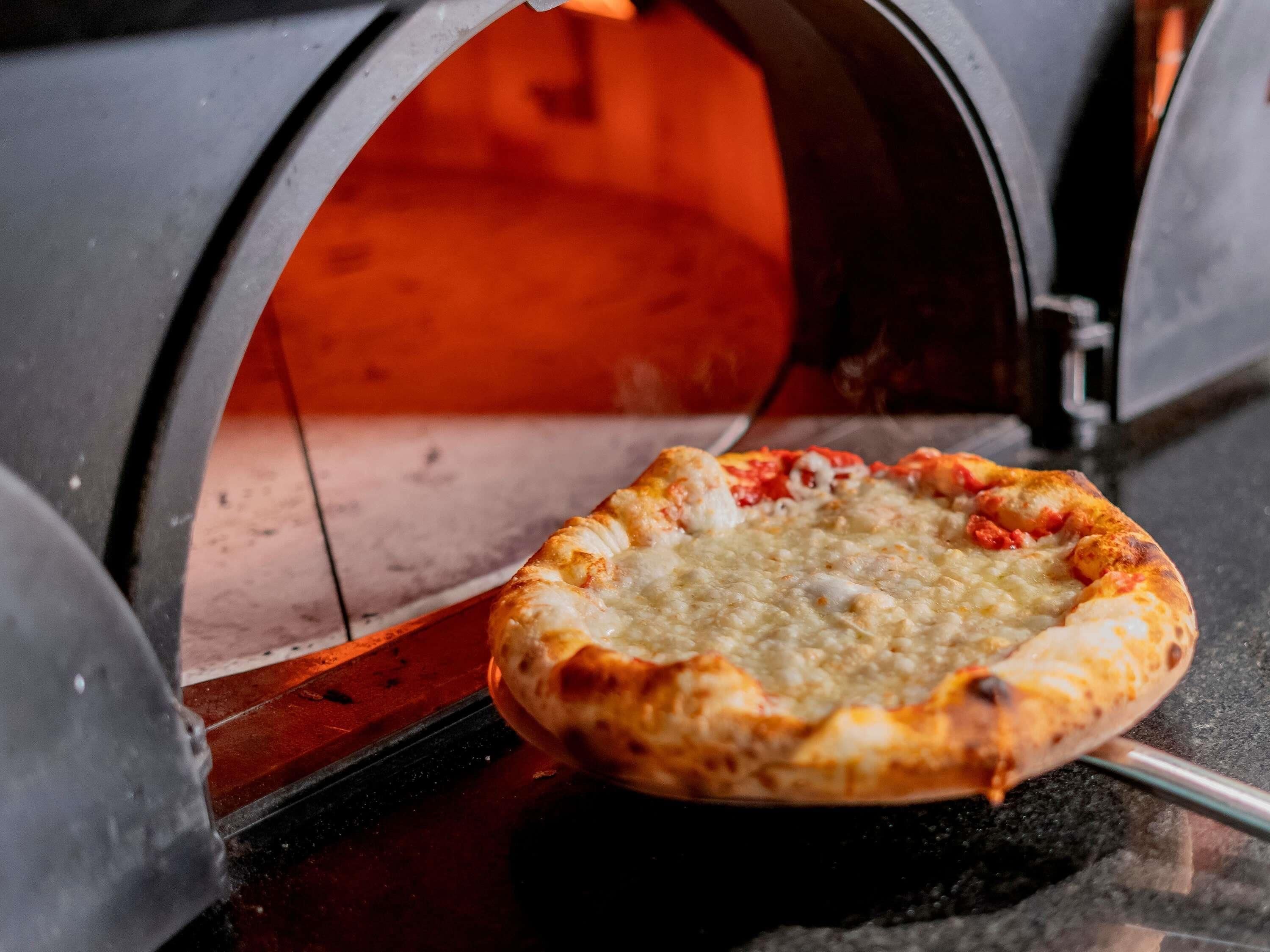 Pizza in een bakstenen oven.