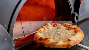Pizza in een bakstenen oven.