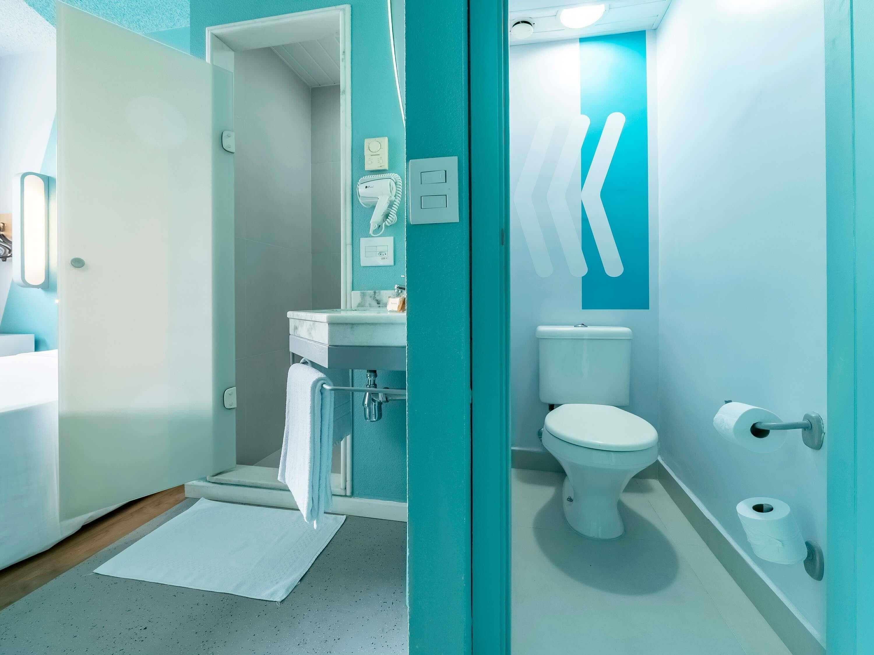 A modern bathroom with a toilet, sink, and towel rack.