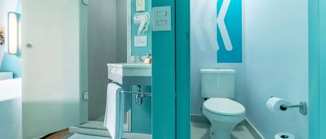 Un baño moderno con inodoro, lavamanos y toallero.