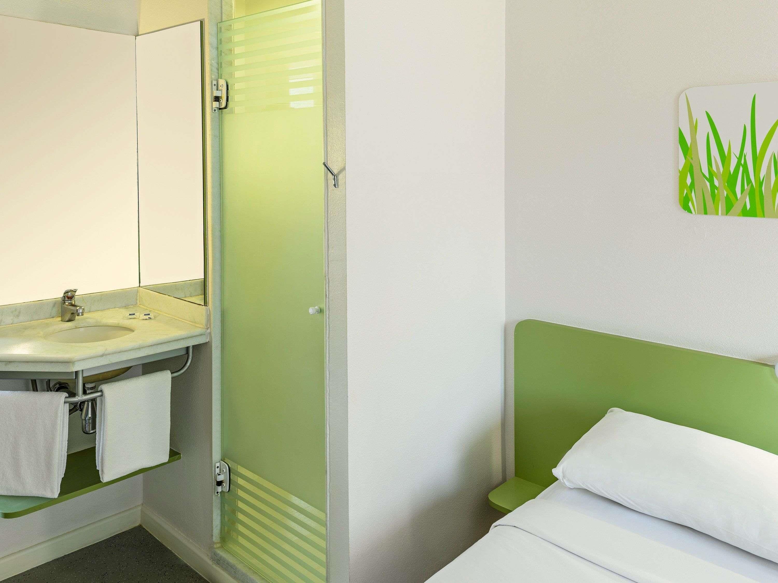 A bathroom with a sink, mirror, and towel rack.