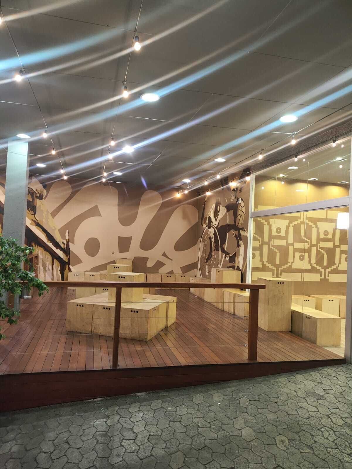 Un interior moderno con piso de madera, una escalera y una pared con diseño geométrico.