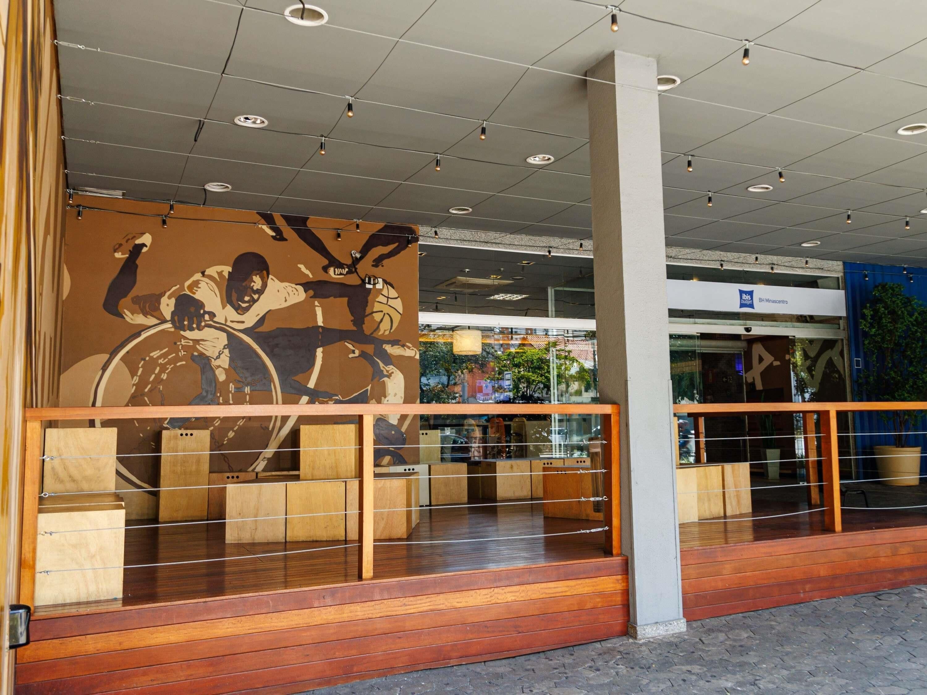 A modern interior with a large mural, wooden flooring, and a glass railing.