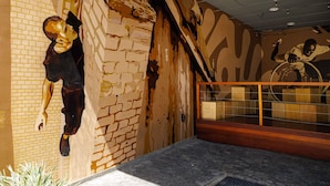 Ein Zimmer mit Backsteinwand, einer Holztreppe und einem Glasgeländer.