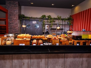 Ein Frühstücksbuffet mit verschiedenen Speisen und einer Kaffeestation.