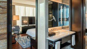 A modern hotel room with a large bed, a TV, a desk, and a bathroom with a large mirror and sink. - Hyatt Regency Shanghai Global Harbor (Shanghai)