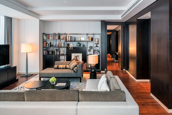 Una sala moderna con un sofá, una mesa de centro, una estantería y un televisor.