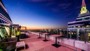 A rooftop terrace with tables and chairs, offering a city view at dusk. - Hyatt Regency Shanghai Global Harbor (Shanghai)
