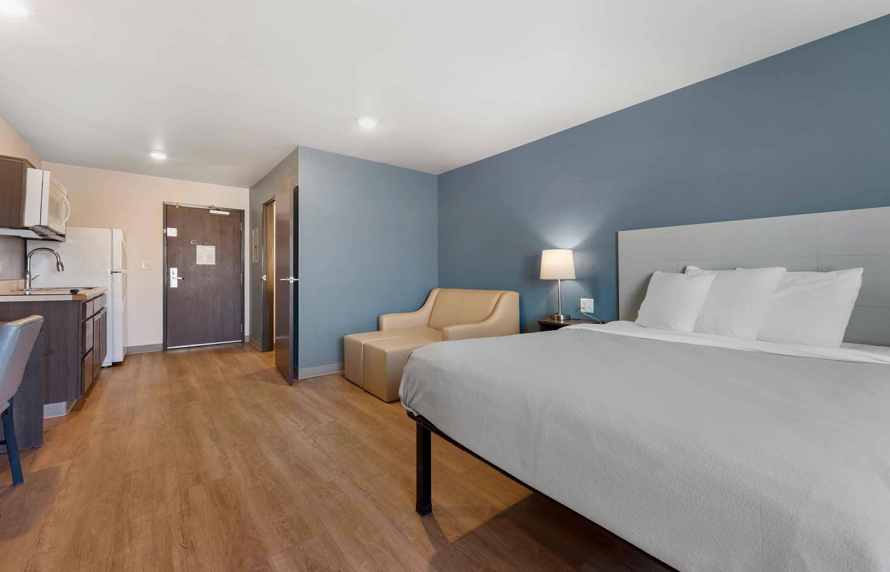 A hotel room with a bed, a desk, and a chair.