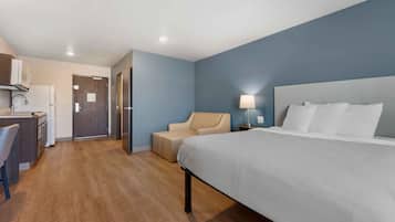 A hotel room with a bed, a desk, and a chair.
